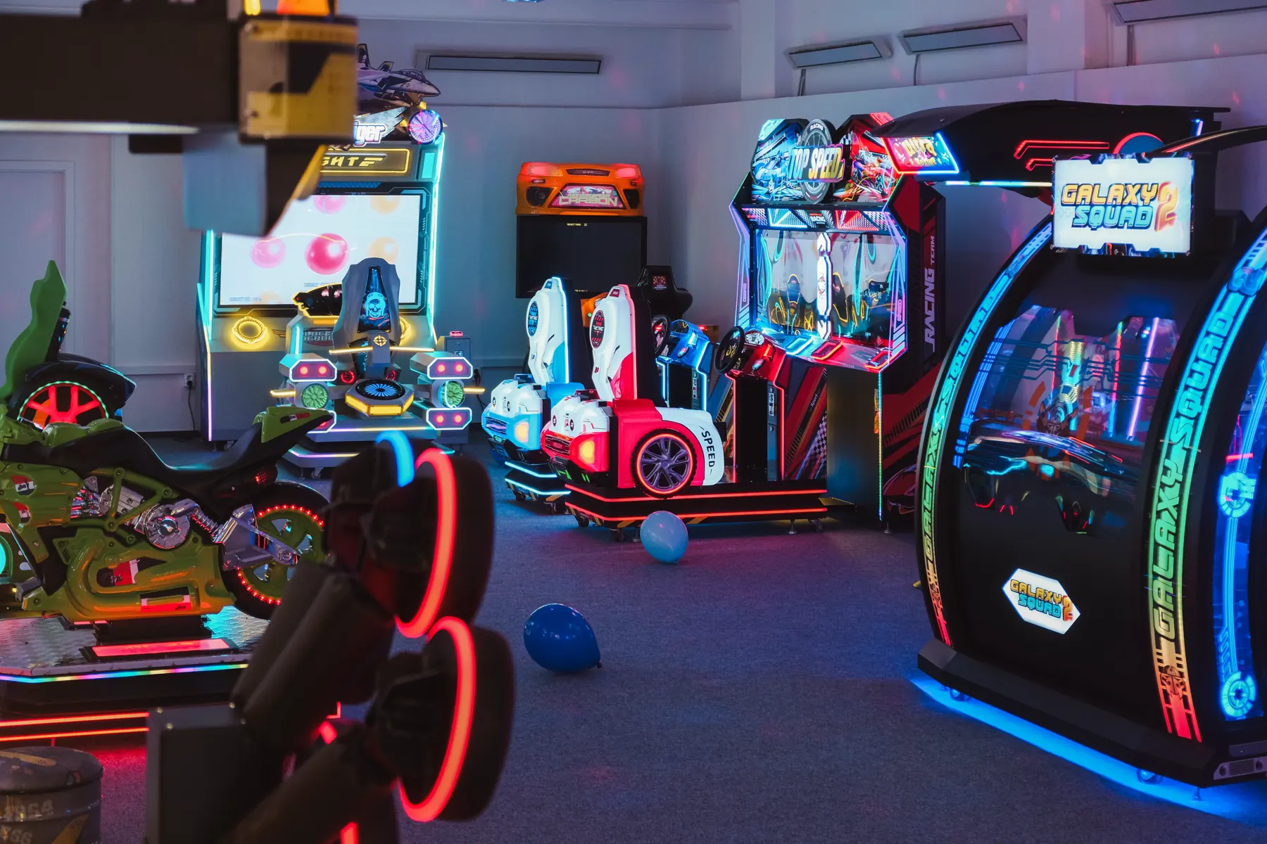 Pohled do herny Gamecentrum plné rozsvícených arkádových automatů